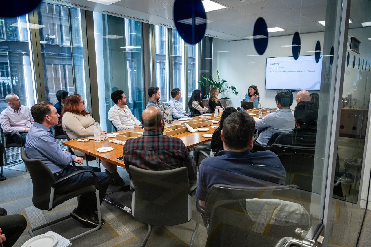 Mobius team in a meeting room discussing investment strategies | Mobius